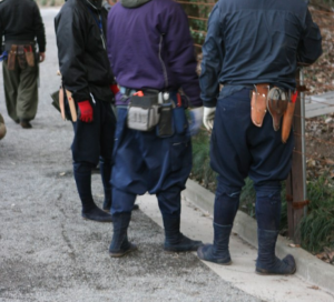 Japanese construction workers wearing "two-toe" or "big-toe" jika-tabi boots and socks while working outdoors on the street.